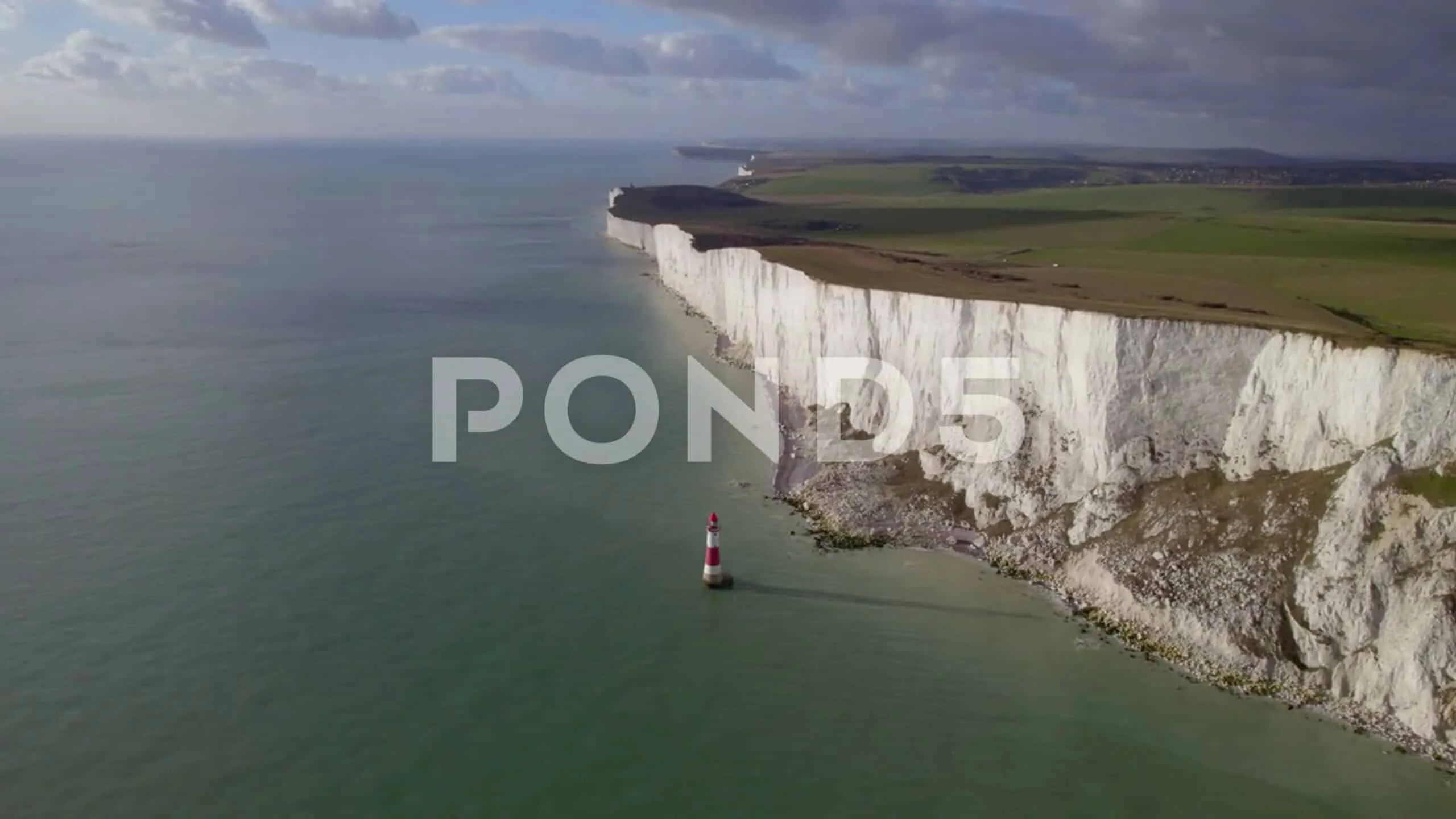 Aerial Shot Flying Towards And Over Lighthouse At Base Of Cliff